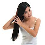 Hair care. Young Asian girl combing hair with finger isolated on white background