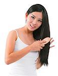 Young Asian girl combing hair over white background
