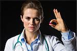 Medical doctor woman showing tablets isolated on black