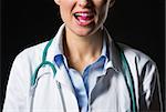 Closeup on medical doctor woman with tablet in mouth