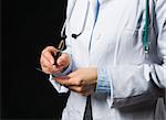 Closeup on medical doctor woman writing prescription on black background