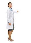 Full length portrait of medical doctor woman pointing on copy space