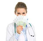 Medical doctor woman hiding behind fan of euros