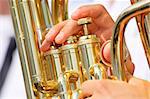 Men playing on a golden  tuba or euphonium