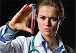 Medical doctor woman looking on test tube with blood isolated on black