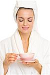 Happy young woman in bathrobe enjoying cup of tea