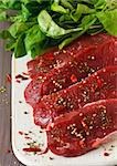 Raw beef meat  with spices and herbs on a kitchen board.