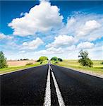 Asphalt road in green meadow. Belarus.  Sepia effect.