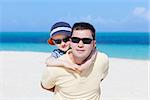 family of two hugging at the perfect caribbean beach, focus on the child