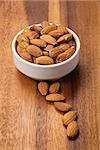 roasted almonds in white porcelain bowl, food background