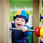 little boy playing on playground at autumn