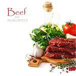 Raw beef meat with spices and herbs on a white background.