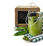 Peasto sauce in glass jar with chalk blackboard tag on a white background.