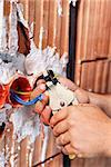 Electrician hands at work - peeling the wires with special pliers