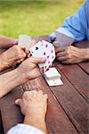 Active retirement, old people and seniors free time, group of three elderly men having fun and playing cards game at park