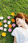 Woman With Flowers Laying Down On the Grass