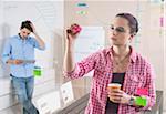 Young Man and Young Woman Working in an Office, Looking Through Glass Board, Germany