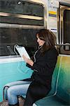 Woman using tablet computer on subway