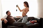 Woman stripping for boyfriend on sofa