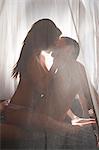 Nude couple kissing on bed