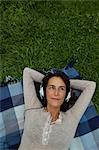 Woman listening to headphones in grass