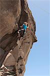 Rock climber scaling jagged cliff