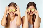 Teenage girls with cucumbers over eyes