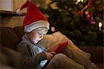 Boy in Santa hat using tablet computer