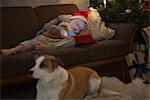 Boy in Santa hat sleeping on sofa