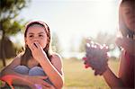 Girls eating fruit in field