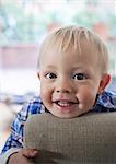 Smiling boy leaning on arm of chair