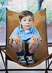 Boy crouching in camp chair