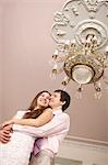 Couple hugging under ornate chandelier