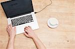 Mans hands, laptop and coffee cup