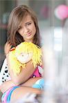 Sad teenage girl hugging doll