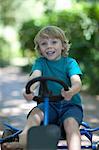Boy riding go-kart on path