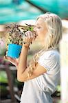 Woman smelling plant in nursery