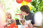 Children blowing noisemakers at party