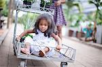 Girl sitting in cart at plant nursery