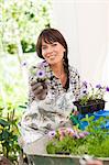 Woman potting plants outdoors