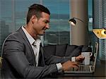 Businessman having cup of coffee at desk