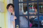 Woman hanging open sign in door