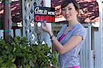 Woman holding open sign outdoors