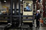 Worker and businessman in metal plant