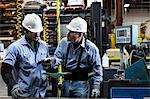 Workers talking in metal plant