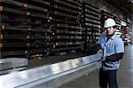 Worker holding metal in plant