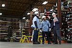 Workers and businessman in metal plant