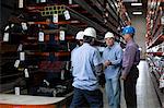 Workers and businessman in metal plant