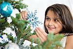 Smiling girl decorating Christmas tree