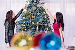 Teenage girls decorating Christmas tree